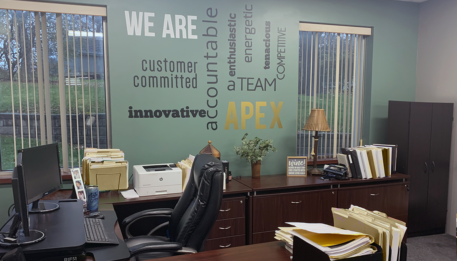 Office of an Apex Industrial Automation executive with the company's core values displayed on the wall as a large art piece.