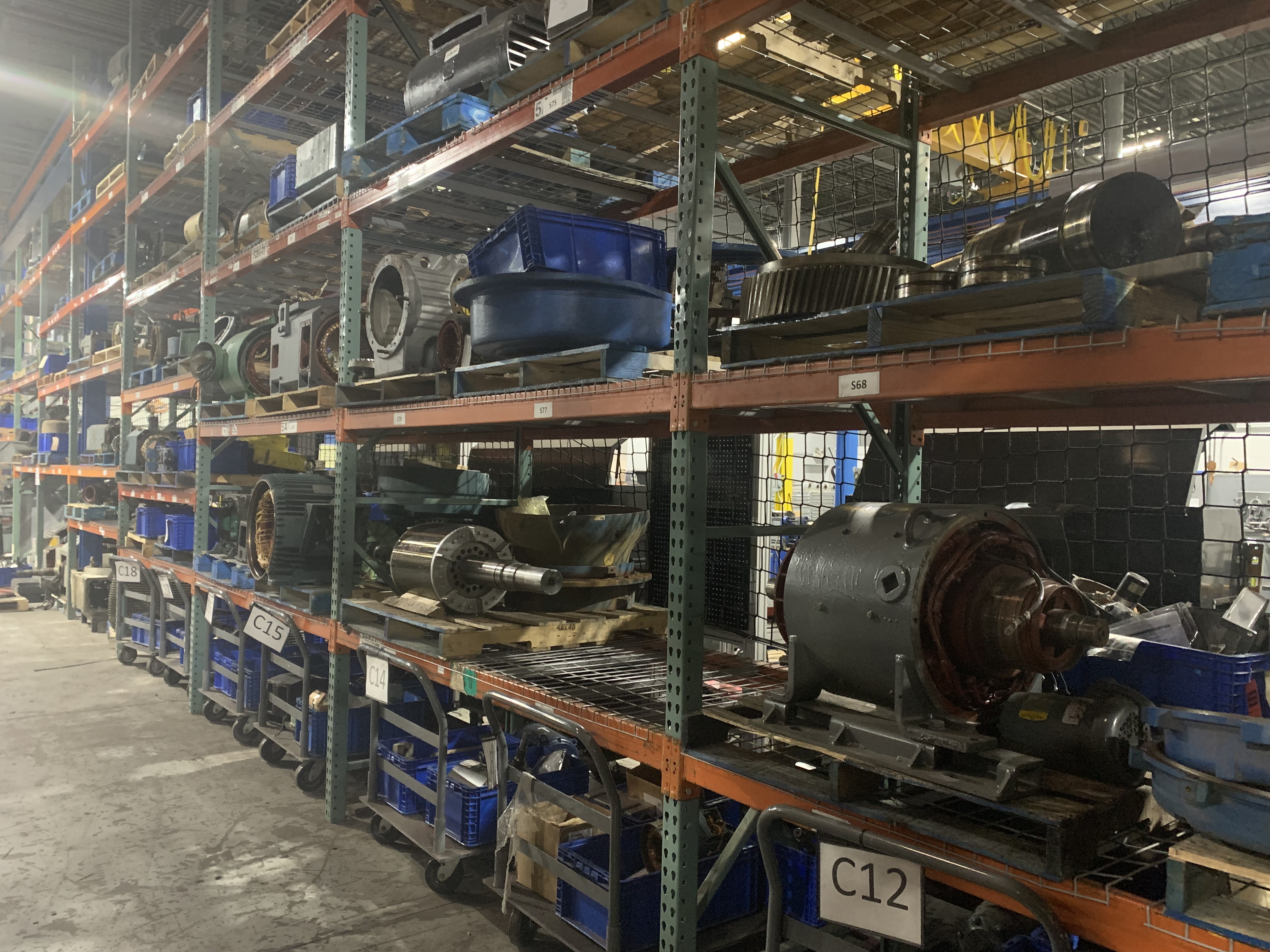Warehouse filled with rows of industrial motors awaiting repair at Apex Industrial Automation.