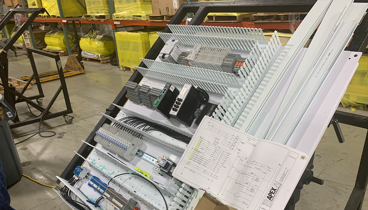 Control panel fabrication in progress at Apex Industrial Automation's Bensenville, IL shop, featuring detailed wiring and labeling on a tilt table.